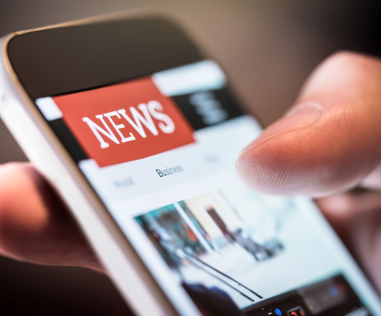 A person using a smartphone to read the news.