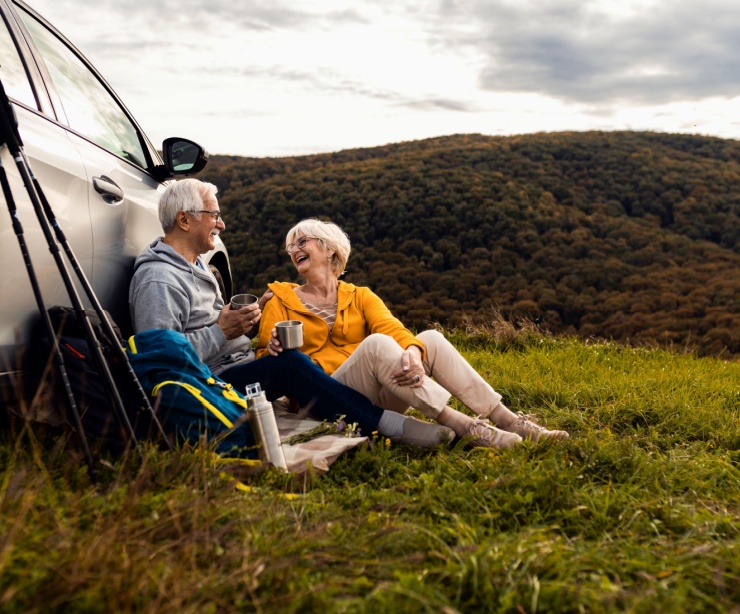 An older couple resting after a hike.