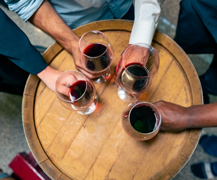 A group of people holding glasses of red wine.