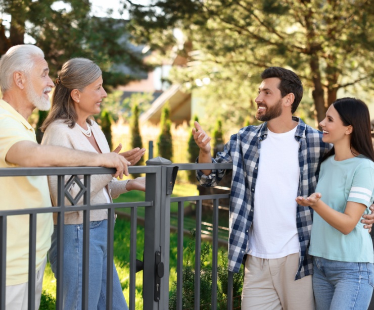 A young couple talking to their older neighbours.