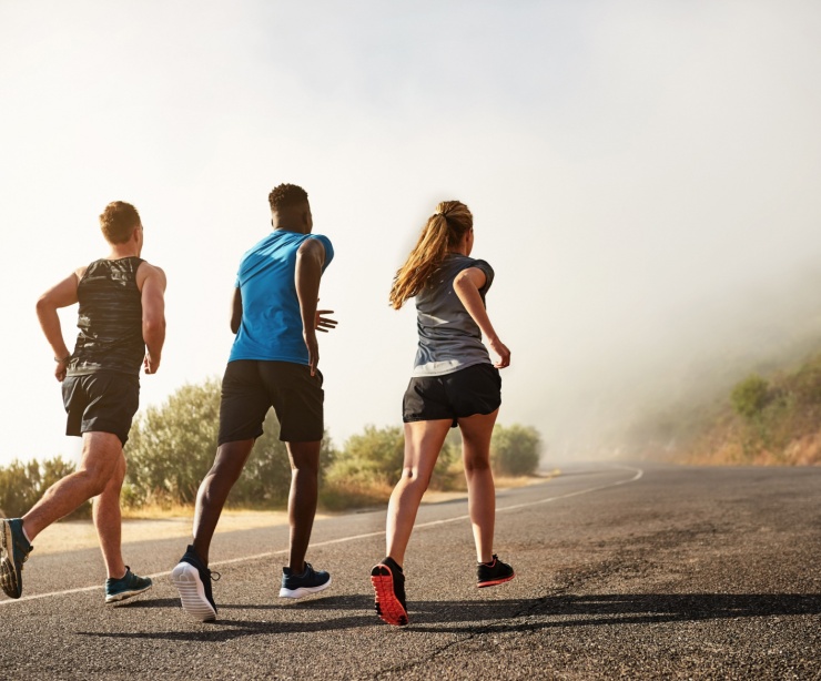 Three people running outdoors.