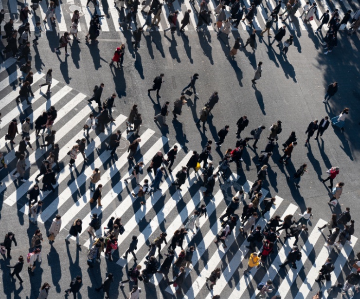 A crowd of people crossing a road.